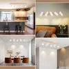 A collage of four images showing a wooden ceiling light fixture with multiple white spotlights in different room settings. Produktbild-Vorschau
