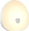 A white, rounded object with a soft, warm light emanating from it, featuring a small, darker circular indentation in the center. Produktbild-Vorschau
