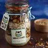 A jar of homemade granola is displayed with decorative tags and a small bowl of granola in the background. Anteprima dell’immagine prodotto