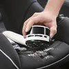 A hand is holding a mini vacuum cleaner and cleaning crumbs from a car seat. Anteprima dell’immagine prodotto