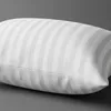 A close-up, side view of a white striped pillow on a gray background. Produktbild-Vorschau