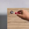 A hand using a screwdriver to insert a fastener into a wooden surface. Produktbild-Vorschau