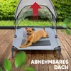 A dog is resting on an elevated pet bed with a canopy outdoors on a wooden deck, with greenery in the background. Produktbild-Vorschau