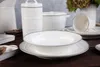 A collection of white ceramic dishes with gray trim, including plates, bowls, a pitcher, and canisters, arranged on a wooden surface. Anteprima dell’immagine prodotto