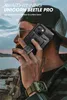 A man wearing a baseball cap and plaid shirt is holding a black smartphone with a protective case while talking on it outdoors. Produktbild-Vorschau