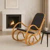 A rocking chair is placed in front of a fireplace in a living room. Produktbild-Vorschau