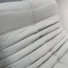 A close-up view of the textured fabric of a beige sofa or armchair. Produktbild-Vorschau
