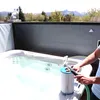 A person is cleaning a hot tub filter with a hose next to a hot tub. Produktbild-Vorschau