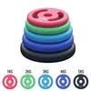 A stack of colorful weight plates with individual plates shown below with their weights labeled. Produktbild-Vorschau