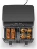 A top-down view of a black and silver dual-basket air fryer with food in each basket. Produktbild-Vorschau