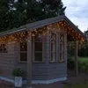 A wooden shed decorated with warm white LED string lights. Podgląd zdjęcia produktu