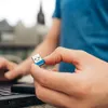 A person is holding a USB flash drive near a laptop. Náhled obrázku produktu