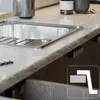 A close-up view of a kitchen sink and countertop. Produktbild-Vorschau