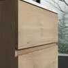 A close-up view of a wooden cabinet with a white top. Produktbild-Vorschau