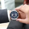 A man's hand wearing a watch, with a suit jacket visible. Produktbild-Vorschau