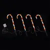 Four illuminated candy canes on a black background. Produktbild-Vorschau