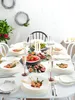 A beautifully set dining table with plates of food, champagne glasses, and candles. Produktbild-Vorschau