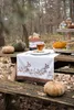 An autumn-themed picnic table setting in a forest with pumpkins, a mug of tea, and decorative mushrooms. Produktbild-Vorschau