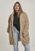 A woman wearing a beige sherpa coat and jeans. Produktbild-Vorschau