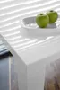 A close-up of a white table with two green apples on a white plate. Produktbild-Vorschau