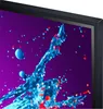 A close-up view of a TV screen displaying a colorful abstract image of paint splashes. Podgląd zdjęcia produktu