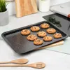 A baking tray with chocolate chip cookies on a kitchen counter. Voir les images du produit