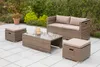 A patio furniture set consisting of a sofa, coffee table, and two ottomans, arranged on a tiled patio with greenery in the background. Produktbild-Vorschau