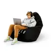 A young person sits on a black beanbag chair using a laptop and wearing headphones. Podgląd zdjęcia produktu