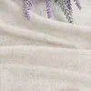 A close-up view of a beige linen fabric with a few sprigs of lavender resting on it. Produktbild-Vorschau
