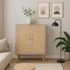 A living room scene featuring a wooden cabinet with rattan doors, a sofa, a floor lamp, and artwork on the wall. Podgląd zdjęcia produktu