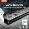 A close-up view of a gutter protection system installed on a gutter, with leaves on top, during a rain shower. Produktbild-Vorschau