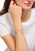 A close-up shot of a woman's arm wearing a charm bracelet with colorful gummy bear charms. Anteprima dell’immagine prodotto
