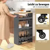 A woman is pushing a narrow shelving unit with wheels in a kitchen. Produktbild-Vorschau