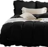 A close-up view of a black duvet cover with ruffled edges and several pillows on a bed. Produktbild-Vorschau