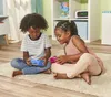 Two children are sitting on a rug, playing with electronic devices. Produktbild-Vorschau