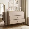 A dresser with three drawers is placed in a room with artwork on the wall and a large mirror. Náhled obrázku produktu
