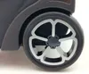 A close-up of a black suitcase wheel with a silver and black rim. Voir les images du produit