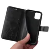 A hand holding a black flip phone case with a floral and butterfly embossed design. Produktbild-Vorschau