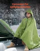 A man wearing a green poncho sits next to a tent in a snowy environment. Anteprima dell’immagine prodotto