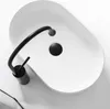 A top-down view of a white oval basin with a black faucet. Náhled obrázku produktu