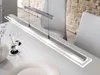 A modern linear pendant light hangs over a white dining table. Produktbild-Vorschau