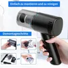A hand holding a black handheld vacuum cleaner, with inset images showing disassembly steps. Produktbild-Vorschau