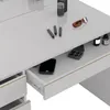 A close-up view of a white vanity table with a drawer pulled out, revealing a smartphone and makeup items inside. Several makeup brushes and a pair of sunglasses are on the table surface. Anteprima dell’immagine prodotto
