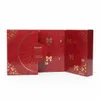 An open red advent calendar with gold embellishments, displaying numbered doors. Produktbild-Vorschau