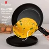 A frying pan with an omelet being slid out onto a plate, with eggs and wheat stalks in the background. Náhled obrázku produktu