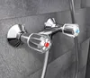 A close-up shot of a chrome shower faucet mounted on a gray tiled wall. Náhled obrázku produktu