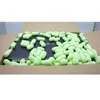 A laptop inside a cardboard box, surrounded by green packing peanuts. Produktbild-Vorschau