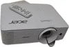 A white Acer projector with a remote control on top, set against a white background. Produktbild-Vorschau