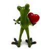 A ceramic figurine of a green frog holding a red heart. Produktbild-Vorschau