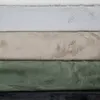 A stack of five different colored plush rugs. Produktbild-Vorschau